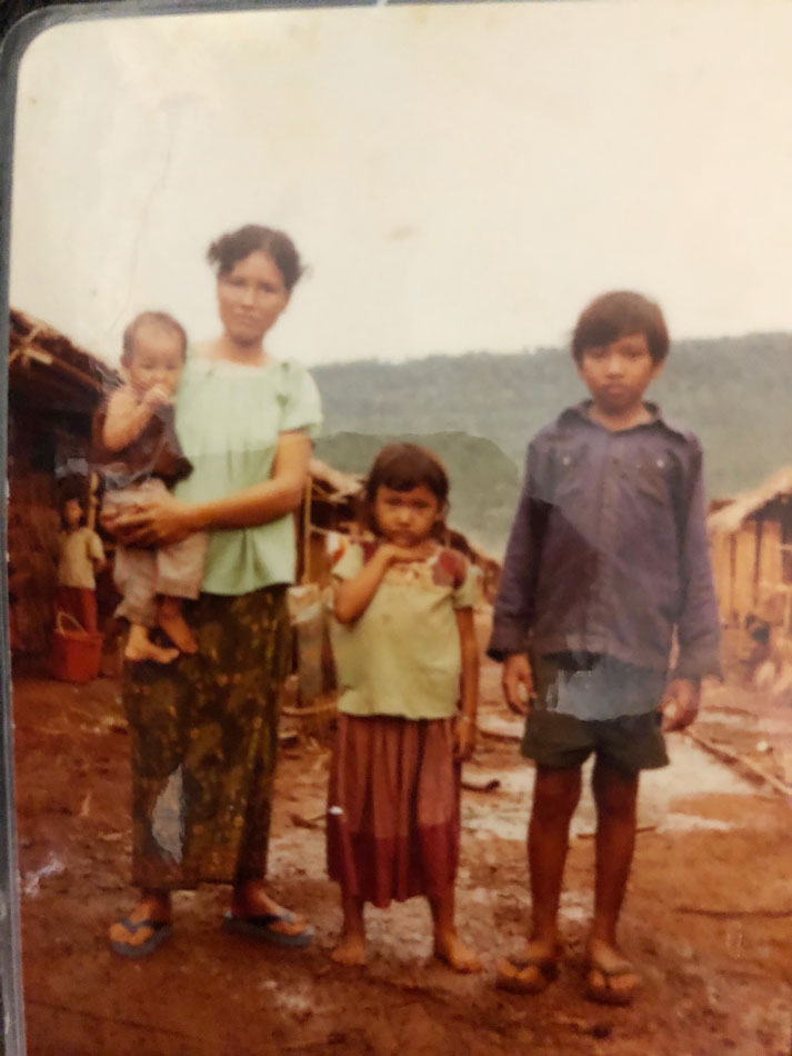  A mother holds her toddler, with her older children standing beside her, for Building Connections blog post.