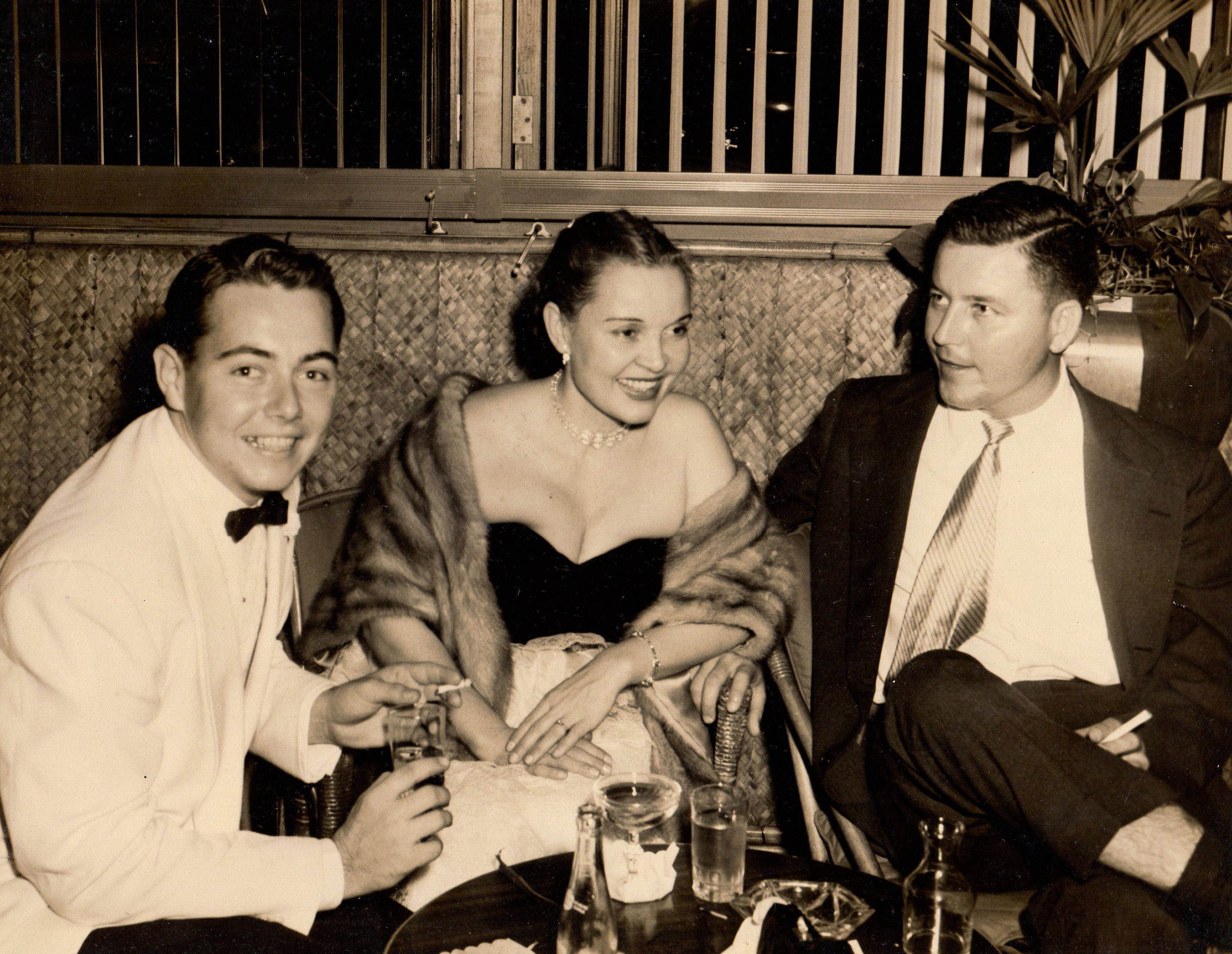 Picture from the 1950s of glamorous young professionals at a bar.