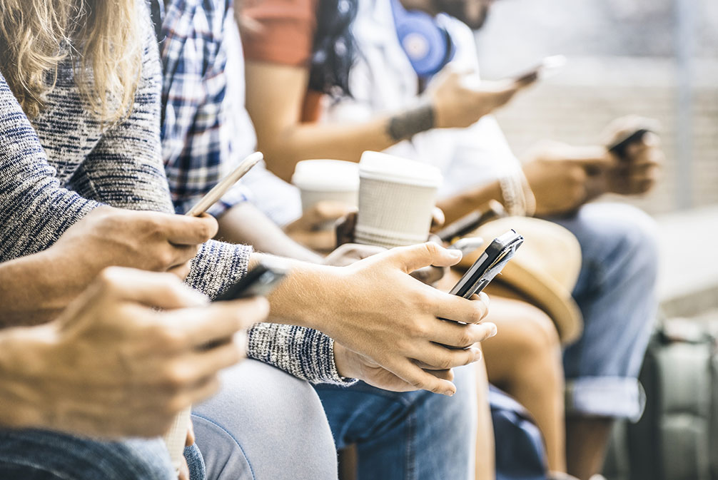 People standing and looking at their devices