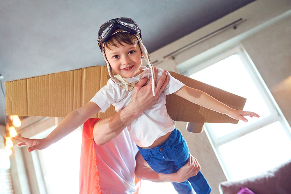 Child dressed as flying superhero