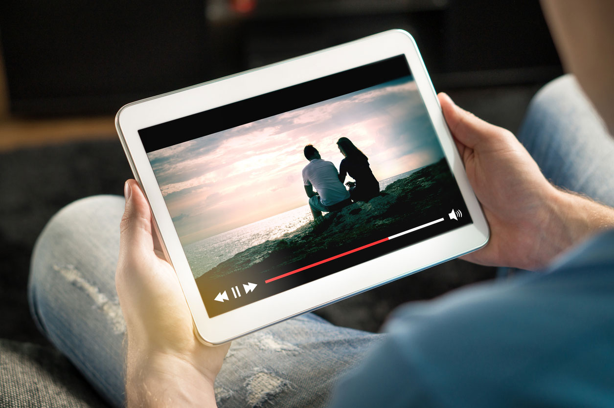 Hands holding tablet on which a video is playing